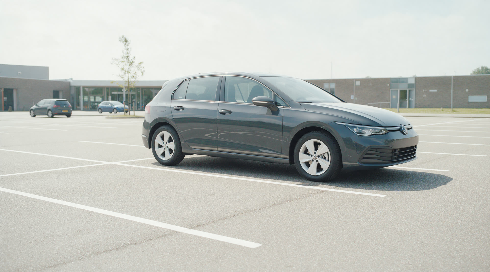 De lesauto staat alleen in een vak op het parkeerterrein van het examencentrum