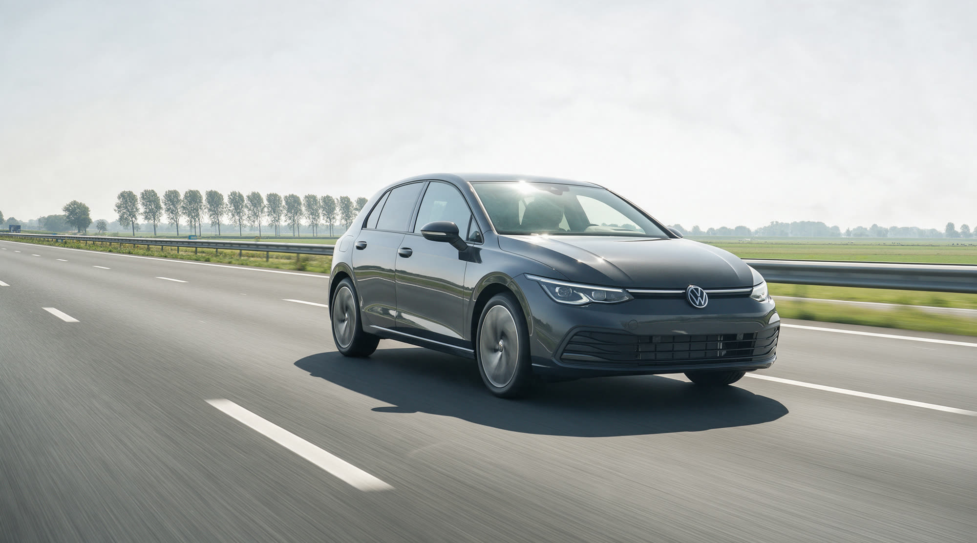 De lesauto rijdt zelfstandig op een driebaans snelweg langs vlak polderlandschap